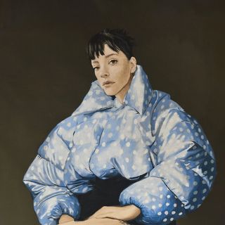 Painted portrait of a woman in an oversized blue polka-dot puffer jacket against a dark background.